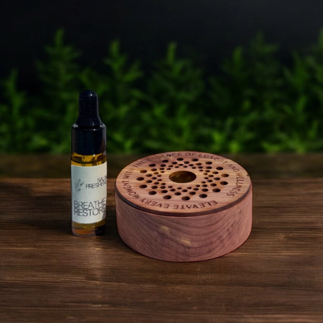 Cedar sauna freshener and essential oil refill on wood surface with eucalyptus greenery in the background